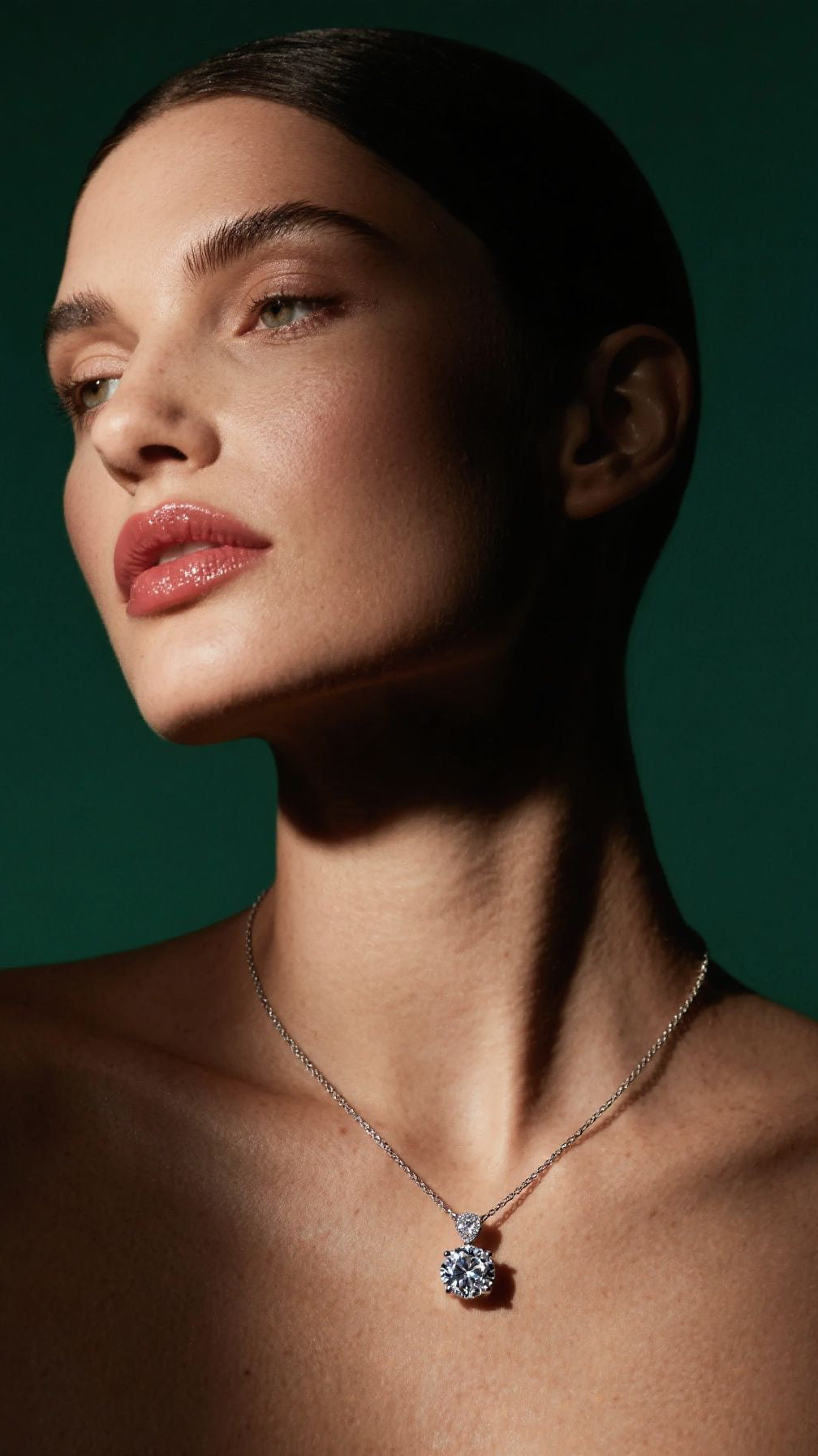 Woman wearing a necklace with a green background